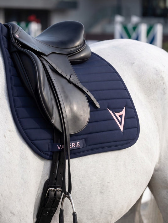 Navy nylon jumping saddle pad with pink logo, studio — Valerie Equestrian Devotion