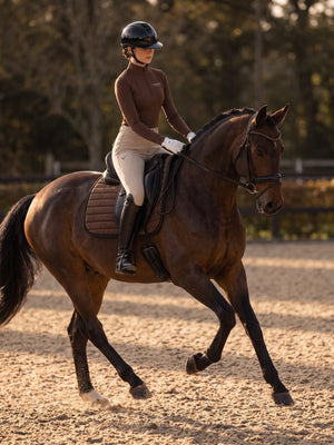 Rider on horseback in a chocolate perforated zip-up turtleneck — Valerie Equestrian Resonance