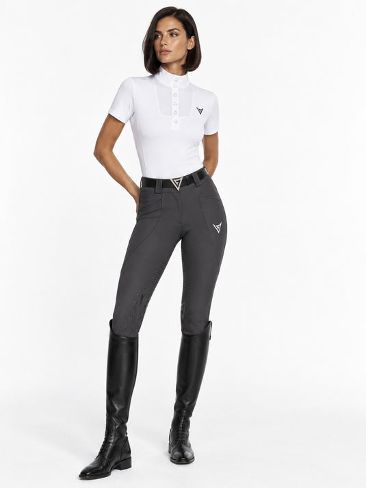 Rider in graphite grey full-seat riding breeches with a white short-sleeve show shirt and black tall boots, full-length view — Valerie Equestrian Momentum
