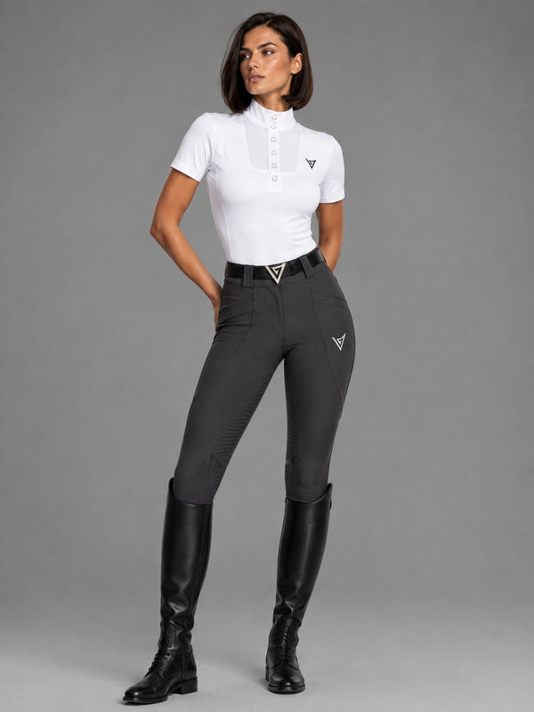 Rider in a white short-sleeve show shirt with graphite full seat breeches and black tall boots, full-length view — Valerie Equestrian Purity